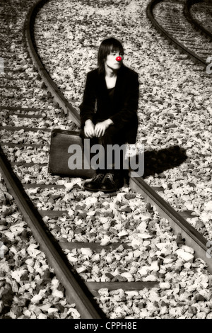der traurige Clown auf Bahngleisen Stockfoto