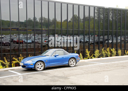 Autos im Parkhaus spiegelt sich in großes Glasfenster Stockfoto