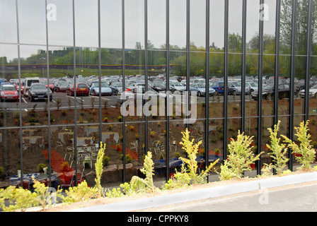 Autos im Parkhaus spiegelt sich in großes Glasfenster Stockfoto