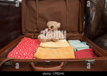 Offenen Koffer mit Kleidung und Teddybär Stockfoto