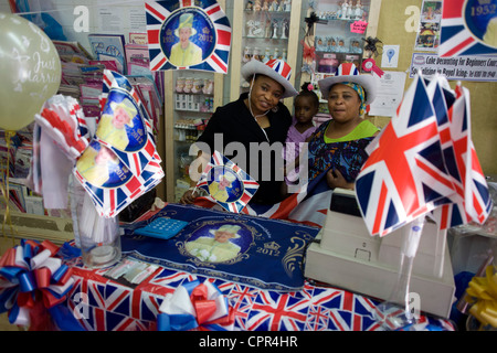 Party Shop-Besitzer mit patriotischen Girlanden, Fahnen und königliche Erinnerungsstücke auf dem Display vor der Königin Diamond Jubilee in South London Unternehmen. Stockfoto