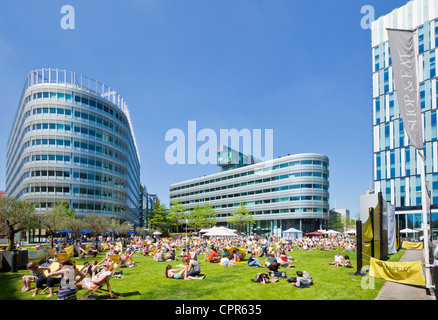 Menschenmassen genießen das warme Wetter und Sonnenschein in der Stadt Zentrum Spinningfields größere Manchester England UK GB EU Europa Stockfoto