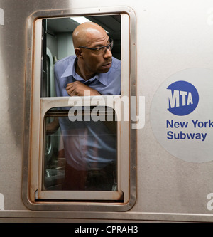 Ein u-Bahn-Fahrer in New York City blickt zurück auf Fahrer überprüfen. Stockfoto