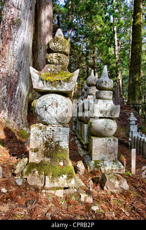 Reihe von fünf-Stein-Türmen, Gorinto, unter hohen Zedernbäumen in der Sonne auf dem alten berühmten Okunoin Friedhof am Mount Koya in Japan. Stockfoto