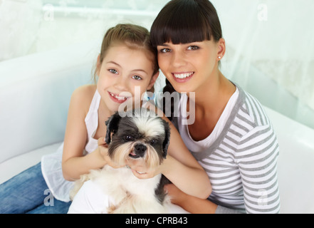 Porträt von glücklichen Mädchen und ihre Mutter Haustier und auf der Suche in die Kamera halten Stockfoto