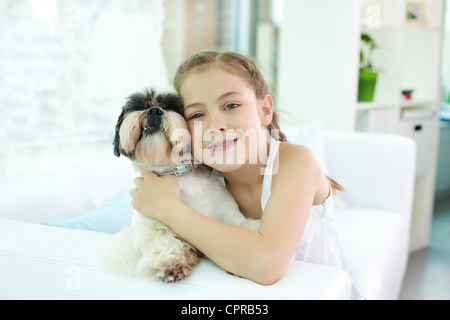 Porträt von glücklichen Mädchen halten Shih-Tzu Hund und Blick in die Kamera Stockfoto