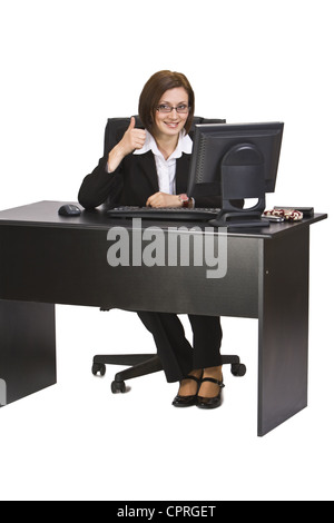 Glücklich Geschäftsfrau mit Daumen-Up auf ihrem Schreibtisch im Büro sitzt. Stockfoto