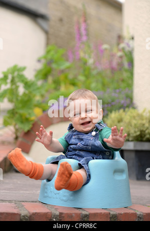 Ein acht Monate altes Baby sitzt in einem Schaum-Kindersitz UK Stockfoto