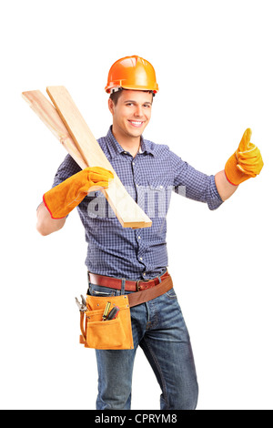 Ein Lächeln auf den Lippen weibliche Zimmermann hielt, Schwellern und Daumen aufgeben isoliert auf weißem Hintergrund Stockfoto