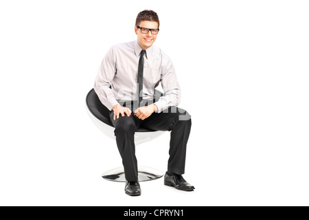 Ein junger hübscher Mann sitzend auf einem Stuhl isoliert auf weißem Hintergrund Stockfoto
