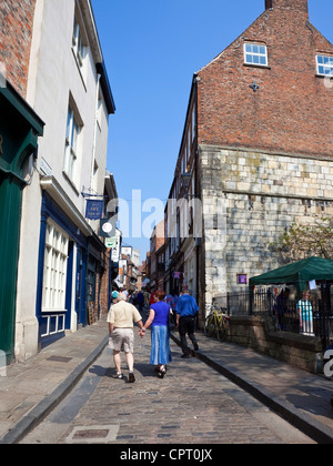 Beschäftigt Straßenszene mit Touristen zu Fuß zwischen den schiefen Gebäuden von der berühmten heilloses Durcheinander in der historischen Stadt von York Stockfoto