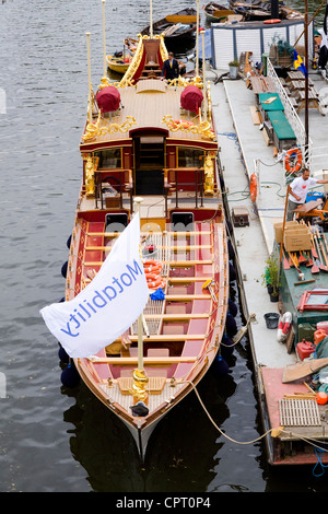 Königin der Royal Barge "Gloriana" an Liegeplätzen in Richmond Upon Thames, abgeschlossen wird und die Motability Nächstenliebe Flagge. VEREINIGTES KÖNIGREICH. Stockfoto