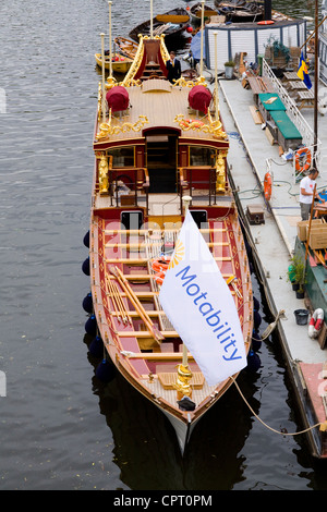 Königin der Royal Barge "Gloriana" an Liegeplätzen in Richmond Upon Thames, abgeschlossen wird und die Motability Nächstenliebe Flagge. VEREINIGTES KÖNIGREICH. Stockfoto