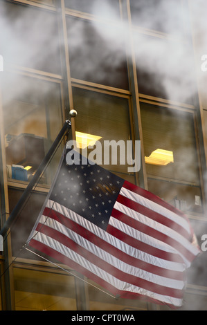 Amerikanische Flagge, verdeckt durch Dampfwolke, fliegen außerhalb Bürogebäude, Manhatan Stockfoto