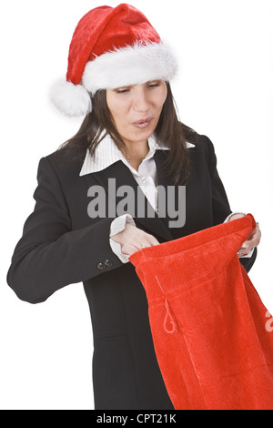 Glückliche junge Frau in einem roten Hut, entdecken Sie Geschenke in Santa es sack Stockfoto