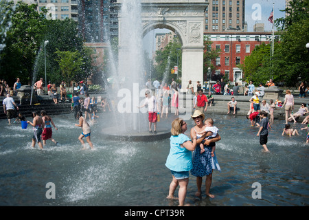 New Yorker und Besucher genießen den Brunnen im Washington Square Park an einem heißen Memorial Day-Feiertag Stockfoto