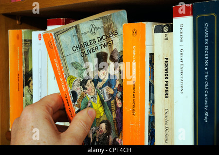 Eine Hand unter Charles Dickens Oliver Twist, von einem Bücherregal Stockfoto