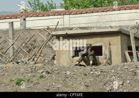 JI'AN, JILIN, CHINA; 20-MAI-2012. Ein nordkoreanischer Soldat mit seinem Maschinengewehr neben ihm sitzt an einem Wachposten und beobachtet die Ufer des Yalu-Flusses gegenüber China. © Olli Geibel Stockfoto