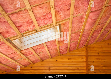 Fiberglas Isolierung in der Dachschräge eines Holzhauses installiert. Stockfoto