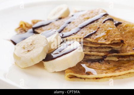 Crêpes oder Pfannkuchen mit Ahornsirup, Bananen und Schokoladensauce. Stockfoto