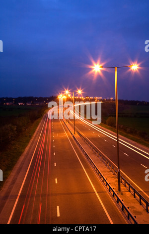 Straße in der Nacht mit Verkehr Trails und Straßenlaternen Stockfoto