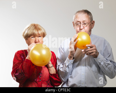 Senior-Sprengung Ballons vor weißem Hintergrund Stockfoto