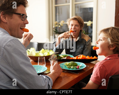 Vater und Söhne mit gesunde Mahlzeit am Tisch sitzen Stockfoto