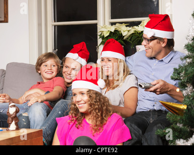 Familie Santa Hüte zu tragen, auf sofa Stockfoto