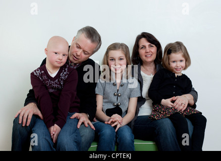 Familienbild mit zwei Töchtern und seinem Sohn mit Down-Syndrom Stockfoto