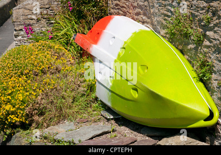 Rot, weiß und grün gestreifte kleines Boot außerhalb Hütte in Fischen Dorf Polperro, Cornwall, UK Stockfoto