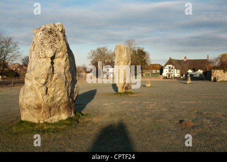 Morgendämmerung an einem kalten, frostigen Wintermorgen in Avebury Stone Circle, Wiltshire, Uk mit der Red Lion Pub im Hintergrund Stockfoto