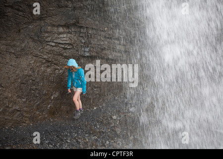 Kind zu Fuß hinter einem Wasserfall in Trafoi-Tal, Italien Stockfoto