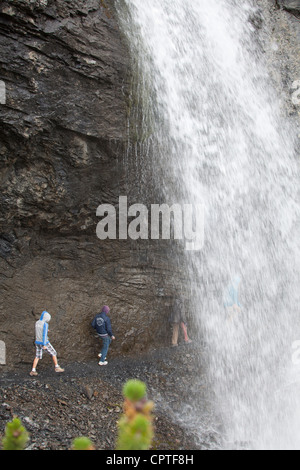 Kinder hinter einem Wasserfall in Trafoi-Tal, Italien Stockfoto