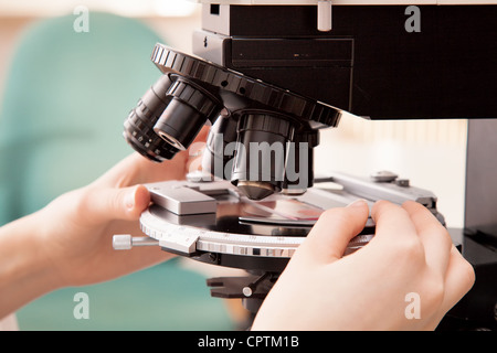 Händen der Wissenschaftler richten Sie die Objekt-Platte am Mikroskop Stockfoto