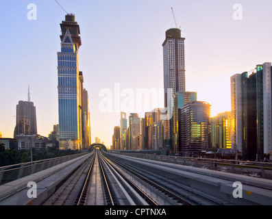 Moderne Stadt im Sonnenuntergang, u-Bahn Überführung mit Schienen, Dubai Stadt in Vereinigte Arabische Emirate Stockfoto