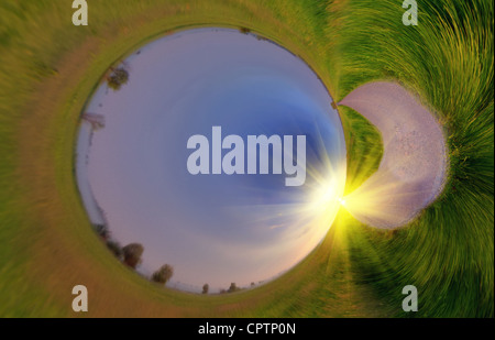 Panorama-Bild sieht aus wie ein grüner Planet mit Sonnenaufgang über asphaltierte Straße Stockfoto