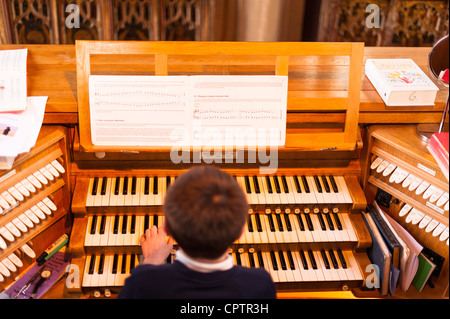Ein 12-jähriger Junge spielen einer Kirchenorgel mit Schwerpunkt auf die Musik im Vereinigten Königreich Stockfoto