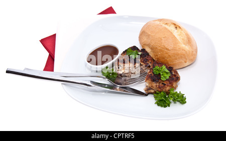 Burger auf einer Platte mit Petersilie und Roll isoliert auf weißem Hintergrund Stockfoto