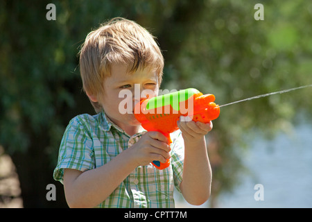 Porträt eines jungen Mannes mit einer Wasserpistole schießen Stockfoto