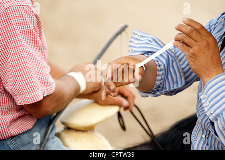 Mexikanische Charro sitzen auf ihren Pferden verbindlich ihre Hände mit Klebeband zur Vorbereitung eines Charros Wettbewerbs, San Antonio, TX, USA Stockfoto