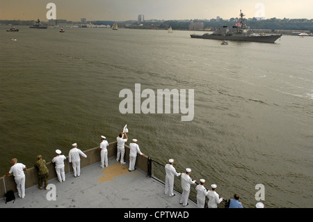 Segler auf Pier 92 beobachten den Raketenlenker USS Donald Cook (DDG-75), der im Rahmen der Parade der Schiffe, die an der Flottenwoche New York 2012 teilnehmen, den Hudson River überquerte. Fleet Week New York 2012 markiert das 25. Jahr, in dem die Stadt die Seeregeln der Nation gefeiert hat. Dieses Jahr fällt die siebentägige Veranstaltung mit dem Gedenken an den zweihundertjährigen Krieg von 1812 zusammen und wird mehr als 6,000 Dienstmitglieder der Marine, des Marine Corps und der Küstenwache sowie Koalitionsschiffe aus der ganzen Welt beherbergen. Stockfoto