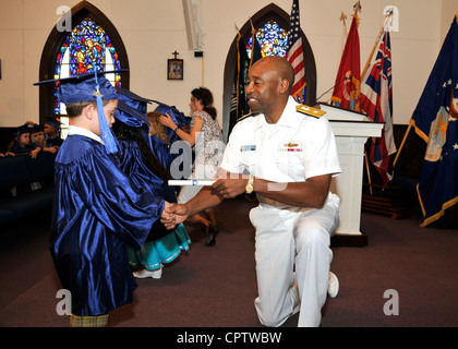 Hintere Adm. Fernandez 'Frank' Teiche, Befehlshaber der Marine Region Hawaii, Hände, die Diplome an den Streitkräften YMCA Vorschule Abschlussfeier für 37 Kinder im Vorschulalter auf der gemeinsamen Basis Pearl Harbor-Hickam Submarine Memorial Kapelle Stockfoto