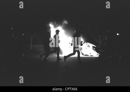 Rodney King Riots. LAPD in Aufruhr Getriebe Datei vorbei an brennenden Streifenwagen am ersten Tag der LA-Aufstände, 29. April 1992. Stockfoto