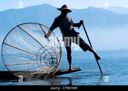 Fischer in Inle See ihren Lebensunterhalt mithilfe einer Coop-ähnlichen Falle mit Netz, um Fische zu fangen und sind bekannt für ihre Bein Rudern Stil Stockfoto