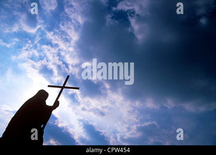 DAS KREUZ HALTEND Stockfoto