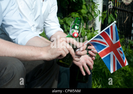 Königin Jubillegal Flottille schwimmende Party, Regent es Canal, East London. Mann hält eine Bierflasche und ein Union Jack-Flagge Stockfoto