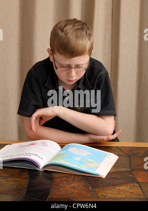 Ein 12 Jahre alter Junge Studien einen Atlas Stockfoto