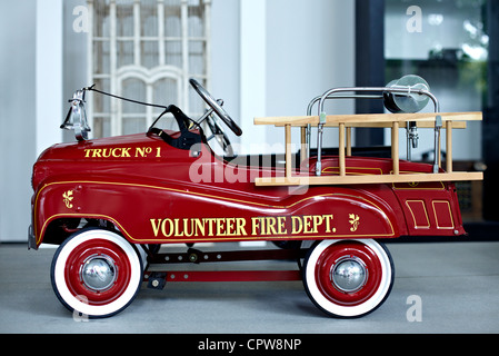 Child's Antique rotes Spielzeugpedalauto auf Basis eines amerikanischen Feuerwehrautos. Stockfoto