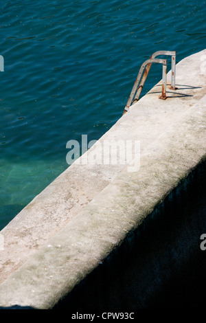 Treppen, die ins Meer aus einer Betonschutzwand Stockfoto