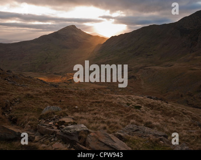 Sonnenuntergang hinter Yr Aran, ein Satelliten-Gipfel Snowdon angesehen vom Watkin Weg Stockfoto